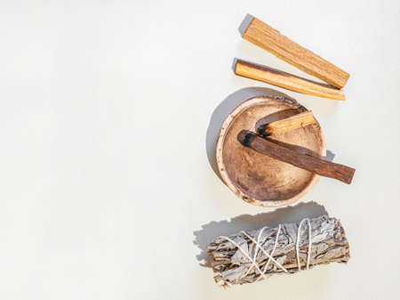Items for spiritual cleansing - sage bundle, palo santo incense sticks on white background. Top view. Copy spaceの写真素材