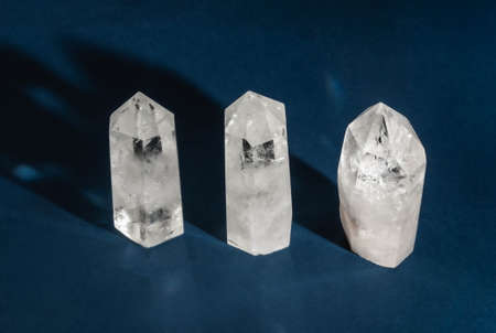 Collection of crystals quartz on dark blue background with shadows. Top view. Copy spaceの写真素材