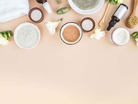 Homemade skincare concept. Organic red and blue clay and other ingredients for beauty facial mask. Candles and flowers for decoration on beige background. top view. copy spaceの写真素材