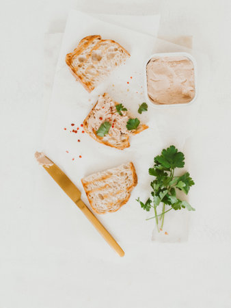 Fresh homemade chicken liver pate on toast homemade bread with parsley and spices on table. top viewの写真素材