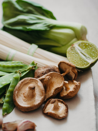 Cooking ingredients for Asian dishes: bok choy, shiitake mushrooms, soba, green peas and garlic on plate. selective focus. front view.の写真素材