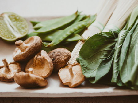 Cooking ingredients for Asian dishes: bok choy, shiitake mushrooms, soba, green peas and garlic on plate. selective focus. front view.の写真素材
