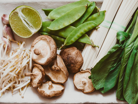 Cooking ingredients for Asian dishes: bok choy, shiitake mushrooms, sprouts, soba, green peas and garlic on plate. selective focus. top view.の写真素材