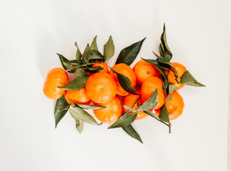Composition from fresh ripe tangerines and leaves on white background, flat lay. Citrus fruit top view. banner, copy spaceの写真素材