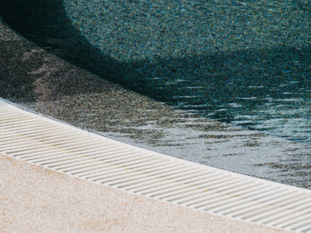 View of round swimming pool side with clear blue water with sunlight shadow wave reflections. Minimal vacation concept backgroundの写真素材