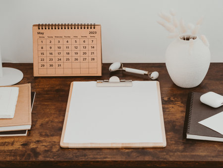 Clipboard with blank paper with copy space on wood brown desk. Aesthetic minimal office desk table...