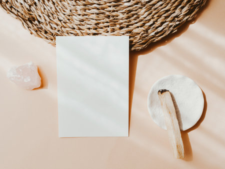 White blank card for text mockup, pink crystal and palo santo on beige background. Minimal concept for busines, message or invitation in pastel colors. top view. copyspace.の写真素材