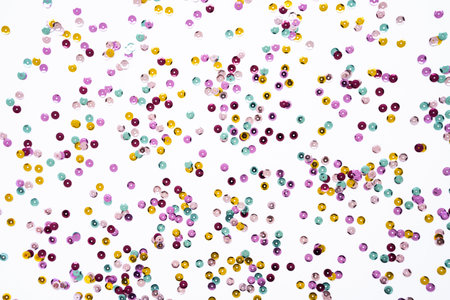 Various colored sequins on a white background. Decorative accessories for sewing and embroidery. Circle shape shining paillettes. Template for card, invitation. Top viewの写真素材