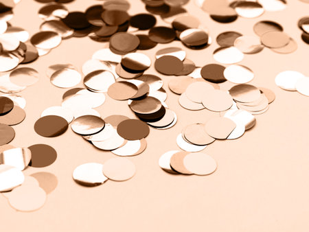 A close-up of scattered round confetti in beige, white, and brown tones on a neutral background. Perfect for festive, celebration, or abstract design themes.の写真素材