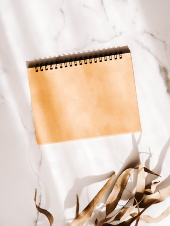 Cover beige cardboard for a calendar or notepad and eucalyptus branch. Resolutions, plan, goals, action, checklist, idea concept. Top view. Flat lay. Copy spaceの写真素材