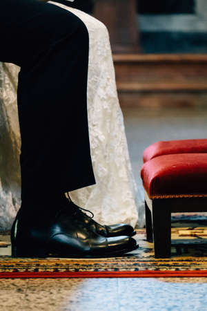 Low angle close up view male and female together sit on wedding ceremony in church with copy paste backgroundの写真素材