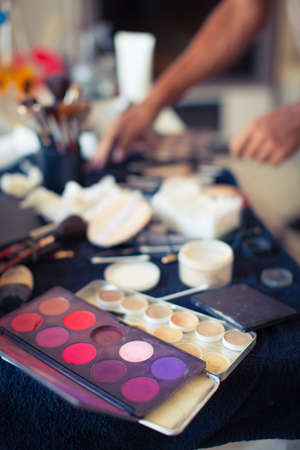 Close up various face cosmetic containers lay on table with mirror. Make up artist tools backgroundの写真素材