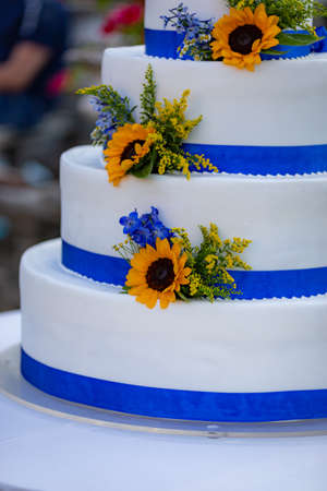 White three-layers wedding cake decorated with sunflowersの写真素材