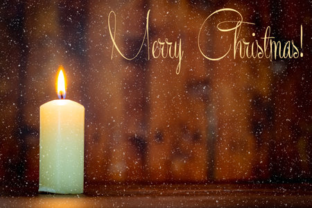 Merry Christmas.Candle lit in a rustic atmosphere and snow effectの写真素材