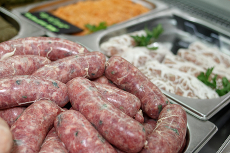sausages of meat in the natural shell on the marketの写真素材
