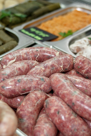 sausages of meat in the natural shell on the marketの写真素材
