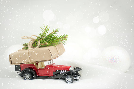 A Christmas card or poster. Red car, snow, gifts, glitter. Blurred fabulous bokeh backgroundの写真素材