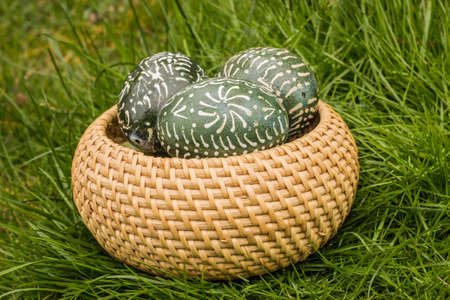 Some Dark Green Easter Eggs in the basketの写真素材