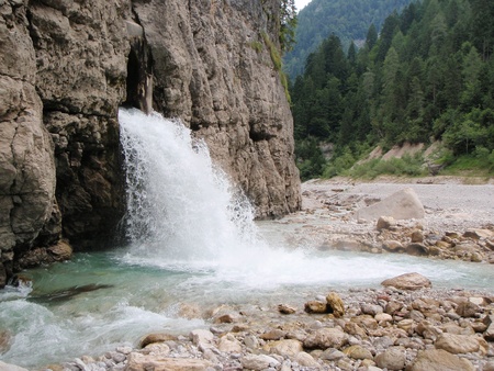 River pouring out of a hole in a rockの写真素材