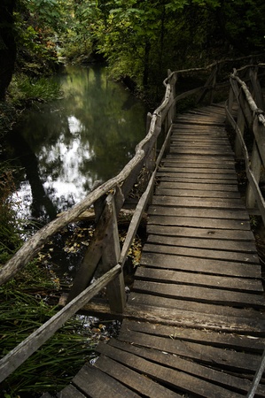 Winding wooden bridge over a riverの写真素材