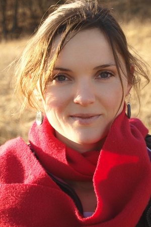 Beautiful young woman with a red scarf smilingの写真素材