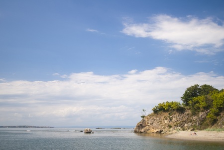 Two people lie on a secluded wild beach enjoying the tranquility and natureの写真素材