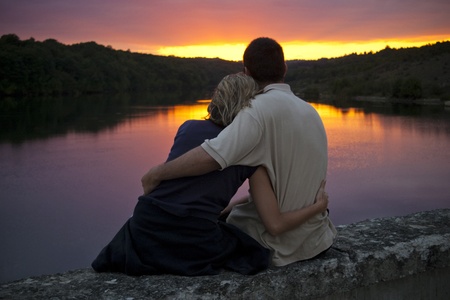 A couple gently embrace as the sun setsの写真素材