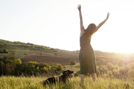 Girl stretches in the sunlight whilst walking her dogの写真素材