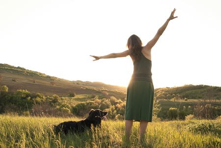 Girl stretches in the sunlight whilst walking her dogの写真素材