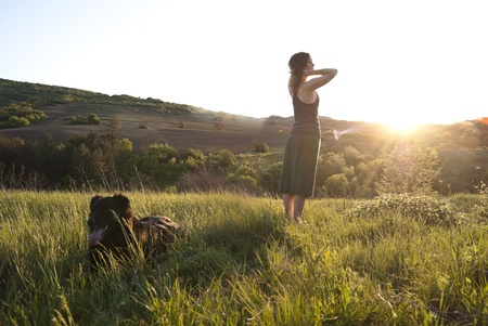 Beautiful girl relaxes in the sunlight whilst walking her dogの写真素材