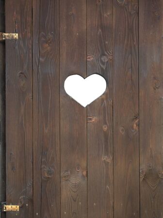 Wooden door that has a heart cut into itの写真素材