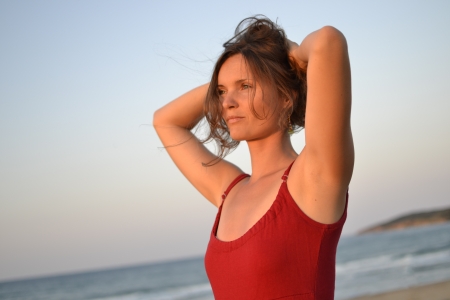Attractive young woman on the beach watching the sunsetの写真素材