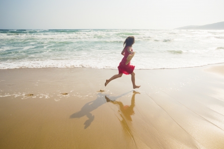 Happy young woman running along the beachの写真素材
