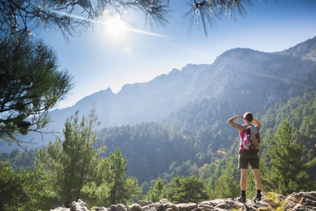 Beautiful fit young woman hiking up a mountain and enjoying at the view on the island of Thassos, Greece.の写真素材