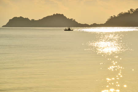 Golden sunrise with a boat at the island of Thassos.の写真素材