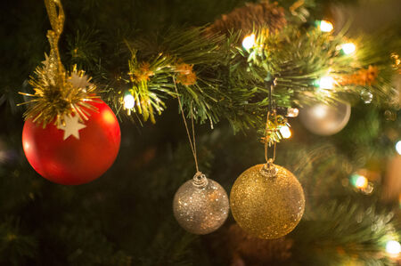 Christmas tree decorated with lights, balls, bells and other ornaments.の写真素材