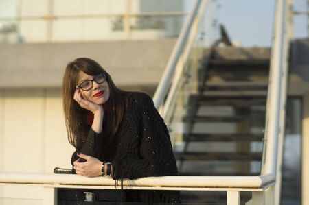 Beautiful young woman enjoying the view from the top of a building.の写真素材