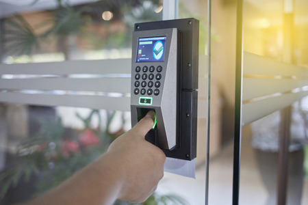 Yong man push finger down on fingerprints scan machine to access the door security systems....