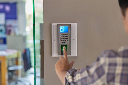 Yong man push finger down on the electronic control machine to access the door