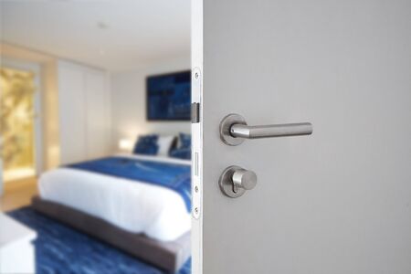 Door handle , door open in front of blur interior room background, selective focusの写真素材
