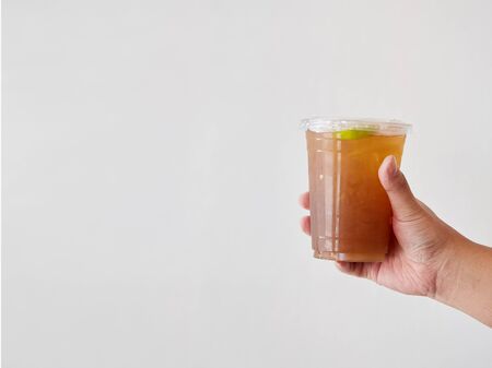 People holding disposable plastic cup in hand on white background. Close up and Selective focus....