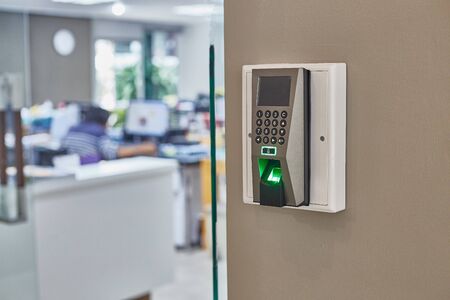 Fingerprint scan machine systems for access interior installed on bricks wall in front of blur...
