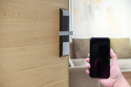 Hotel door security Unlocking by application on mobile phone. Digital door lock, key less system of access door. Close up and selective focus.の写真素材