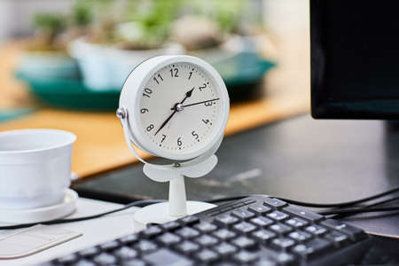 White Clock on wood working table selective focus.
