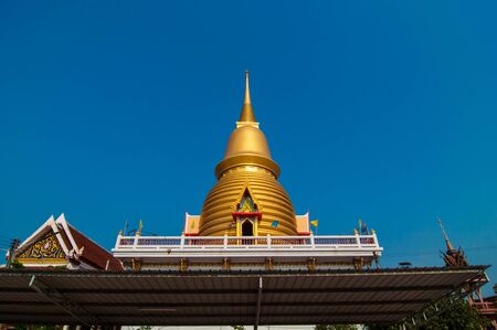 Thailand gold pagoda temple with blue sky background.の写真素材