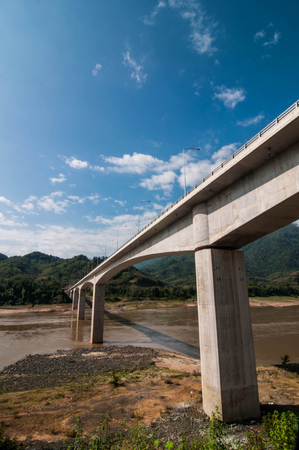 Bridge across the Mekong River Mountains, blue sky backgroundの写真素材
