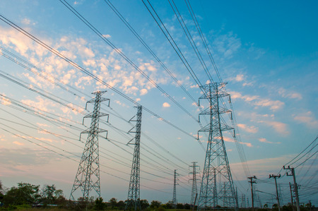 High voltage electricity pylon against the background sky of sunset light colors.