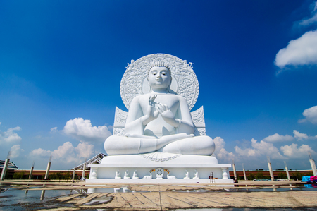 white buddha status on blue sky background in thailandの写真素材