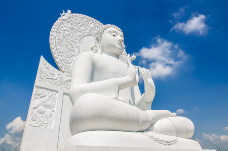 white buddha status on blue sky background in thailandの写真素材