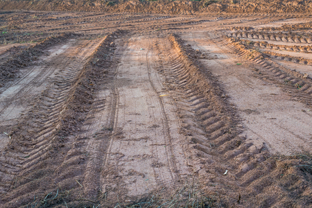 Agricultural field on which drove heavy vehicles. Ruts from the wheels in the mud, formed after the rainの写真素材